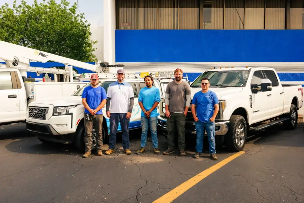 The Bluespan leadership team standing with service trucks in Arizona