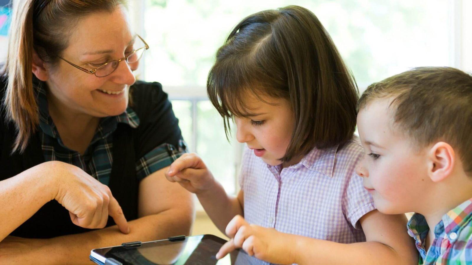Volunteer helping child use laptop as part of Arizona community involvement initiatives