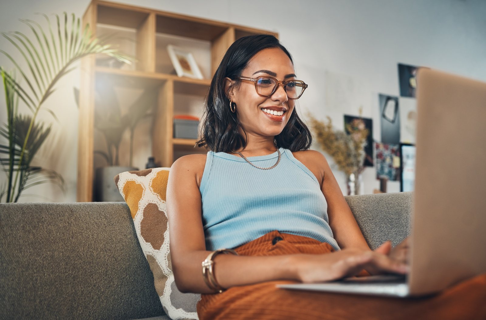 Person relaxing on couch using residential internet service on laptop at home