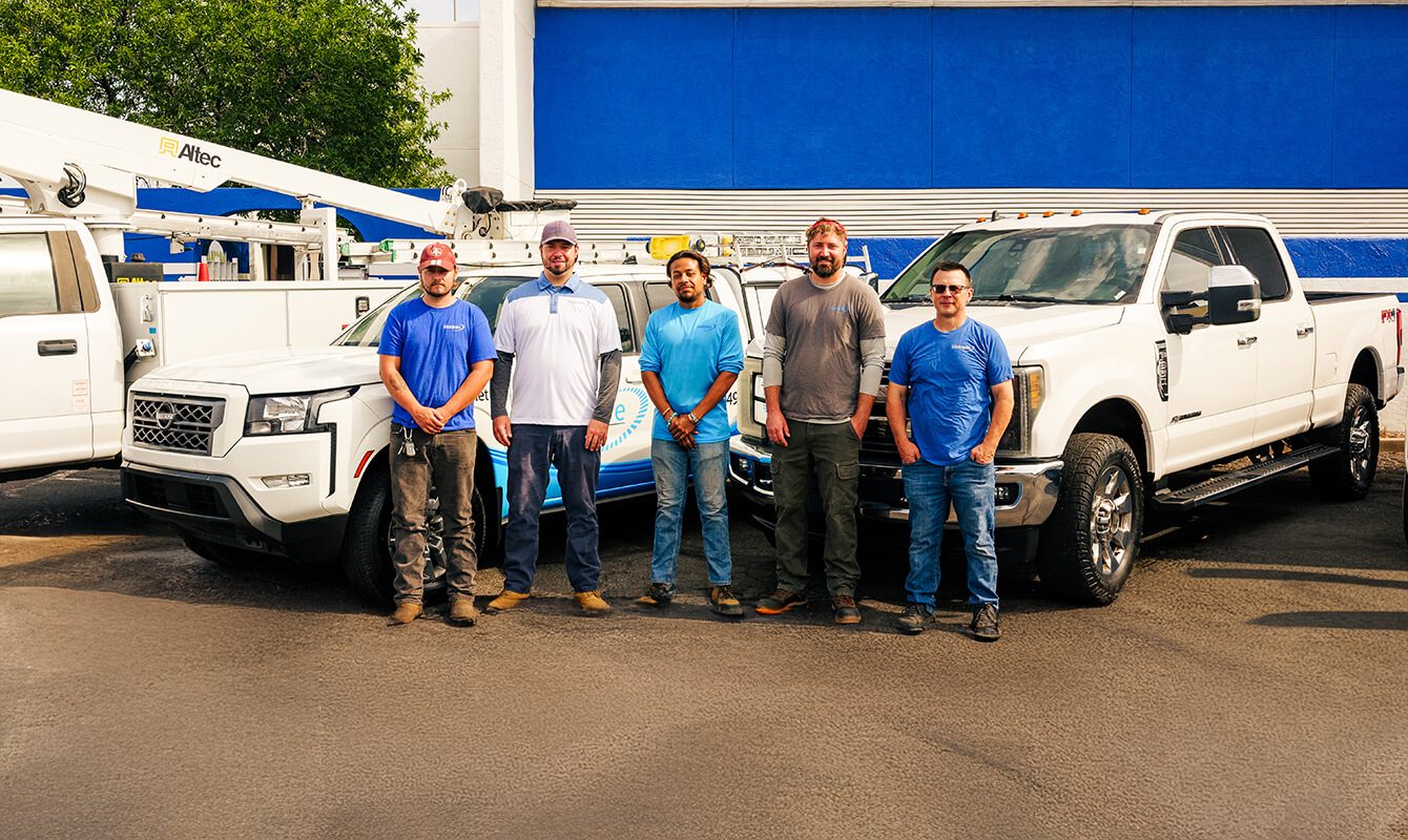 Bluespan team standing by service trucks providing reliable internet service support