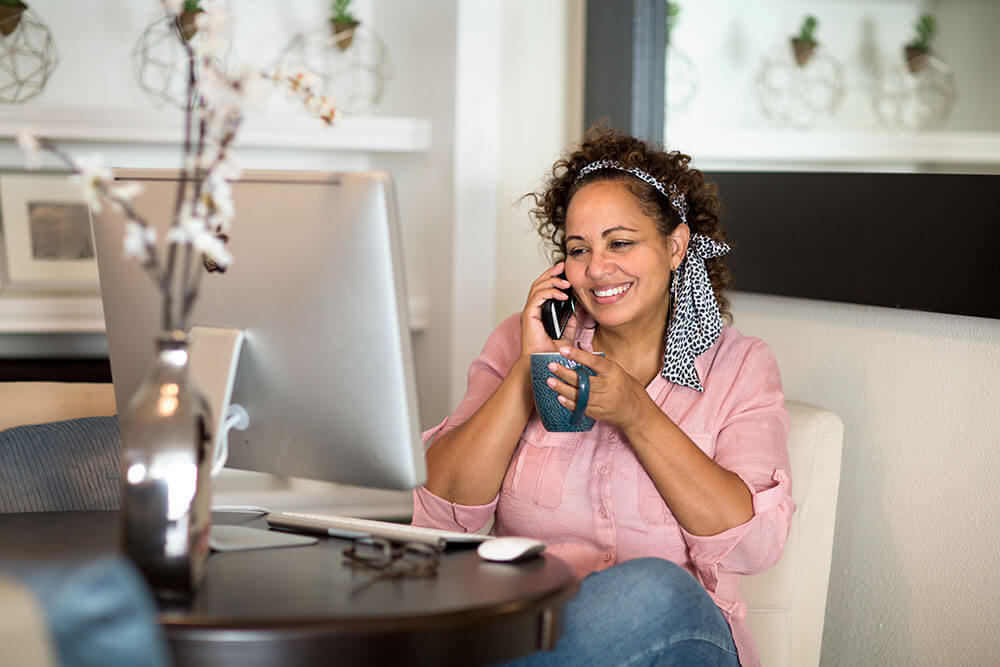 Woman using home phone and home internet services for clear and reliable communication